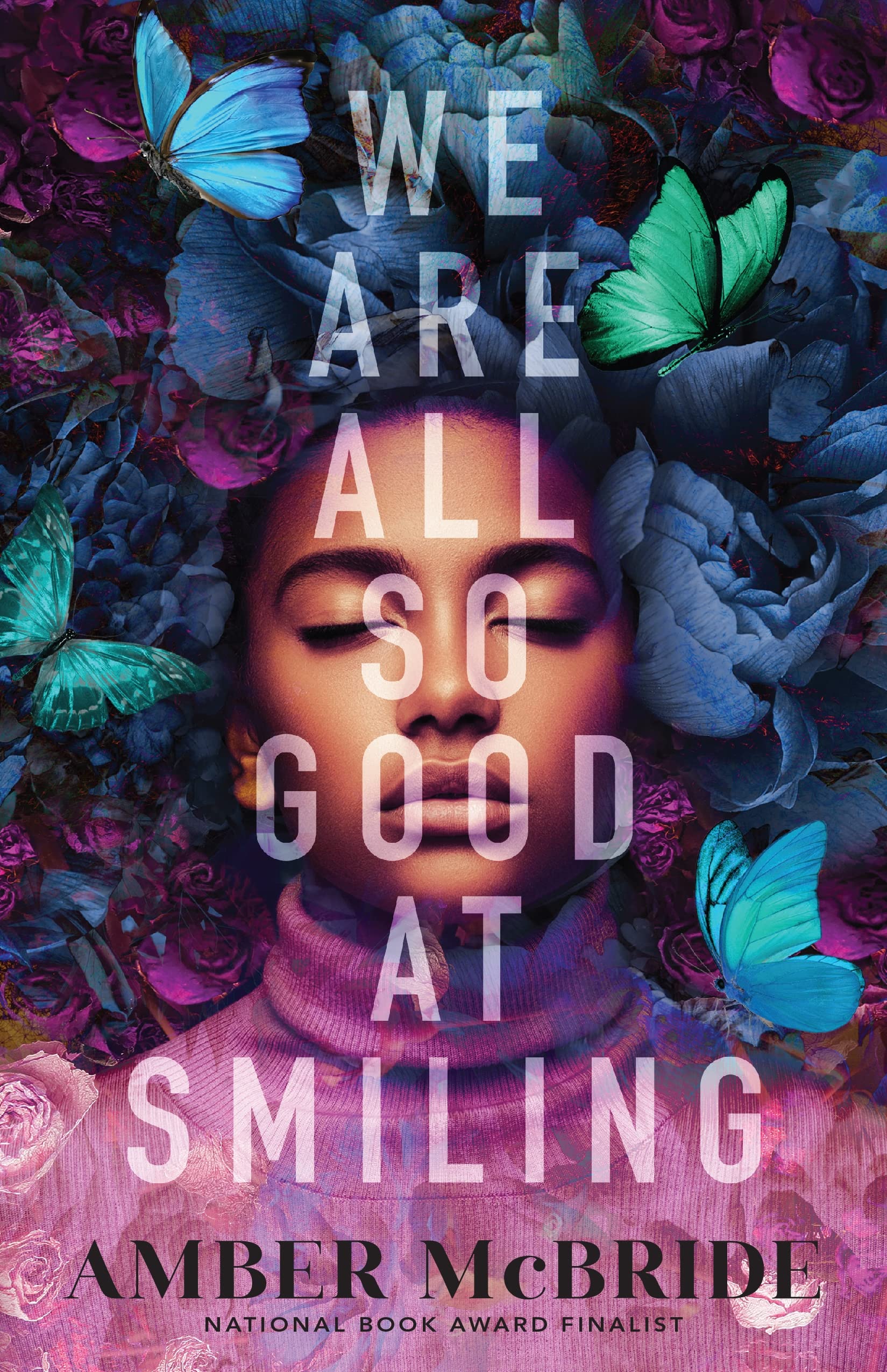 African American teenager with lilac turtle neck in the center of cover. Around the teenagers head where her hair would be are teal, blue, magenta butterflies frame around the face and background. From top to bottom in the center, the title is displayed is white opaque font. "We Are All So Good At Smiling" by Amber McBride.